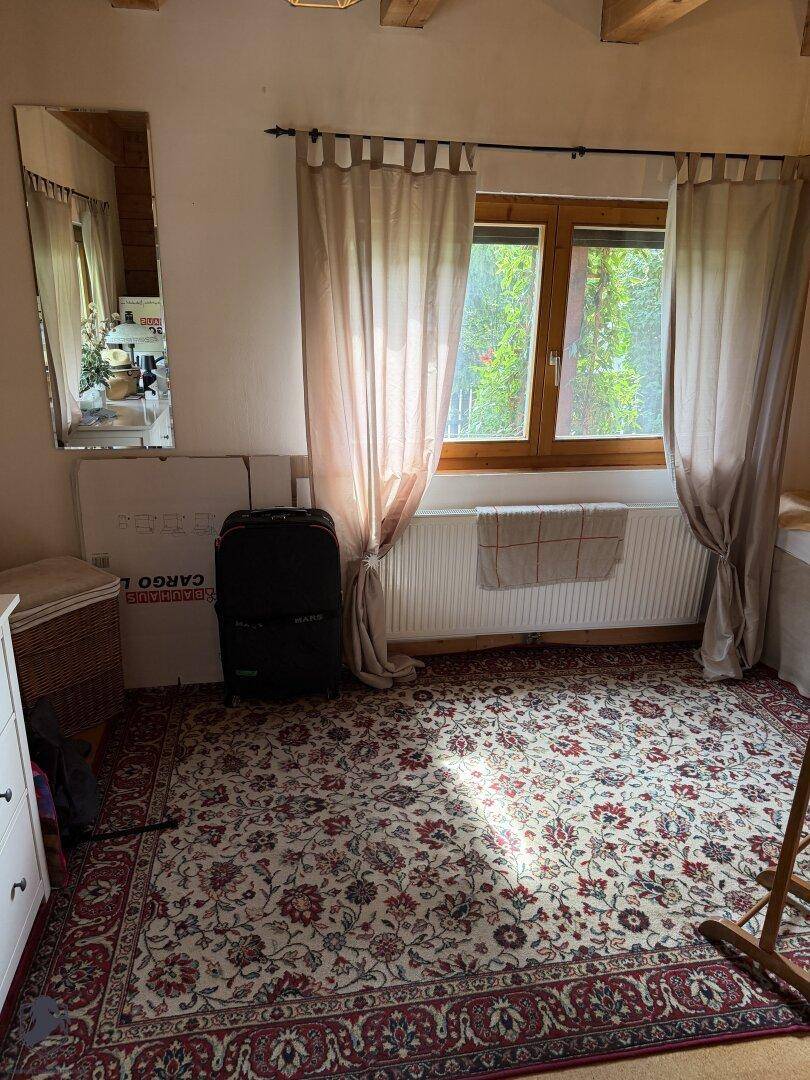 Schlafzimmer mit Teppichboden, Fenster und Vorhängen, bietet eine gemütliche Atmosphäre.