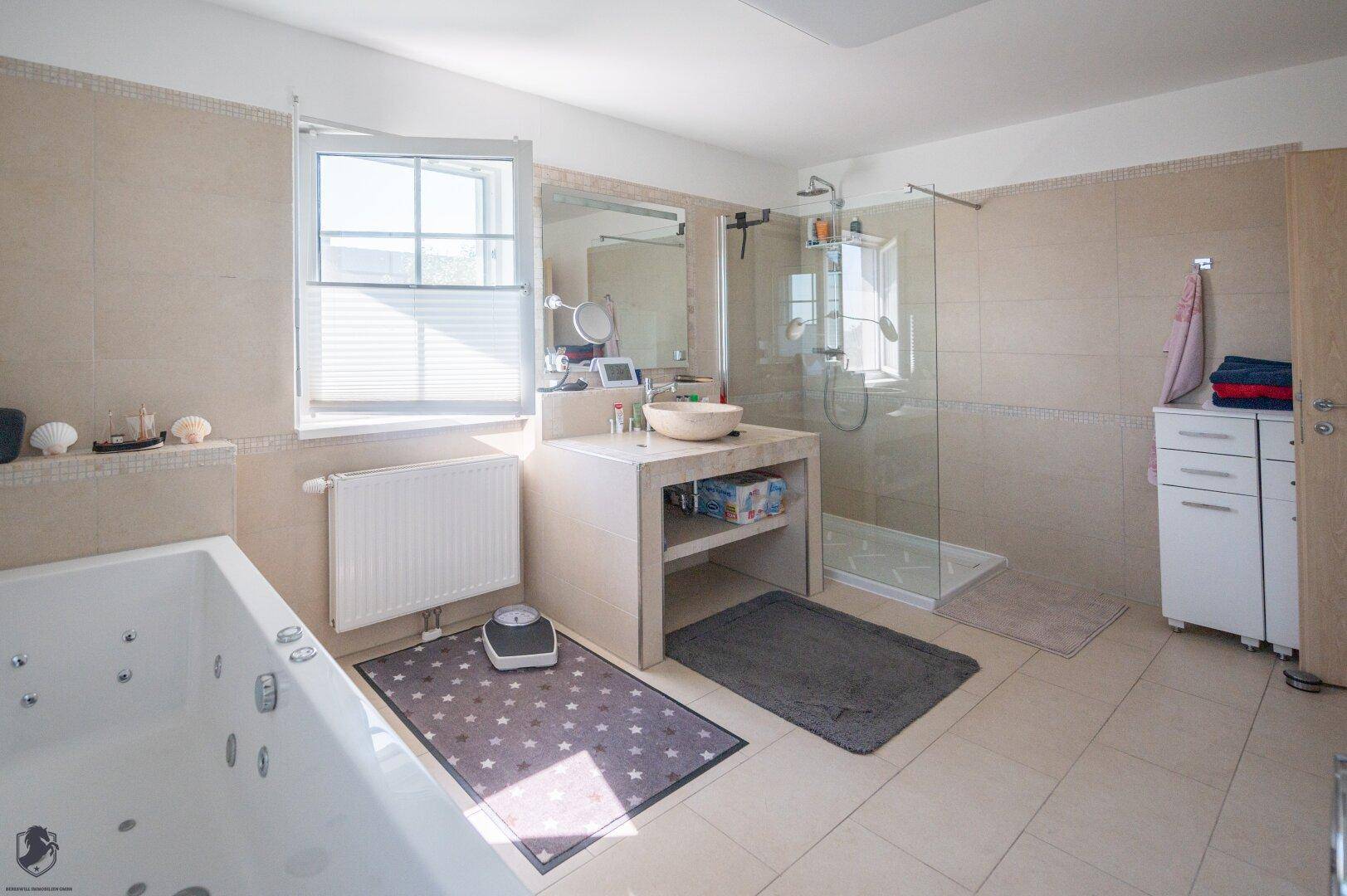 Modernes Badezimmer mit Whirlpool-Badewanne, Duschkabine und großem Fenster für viel Licht.