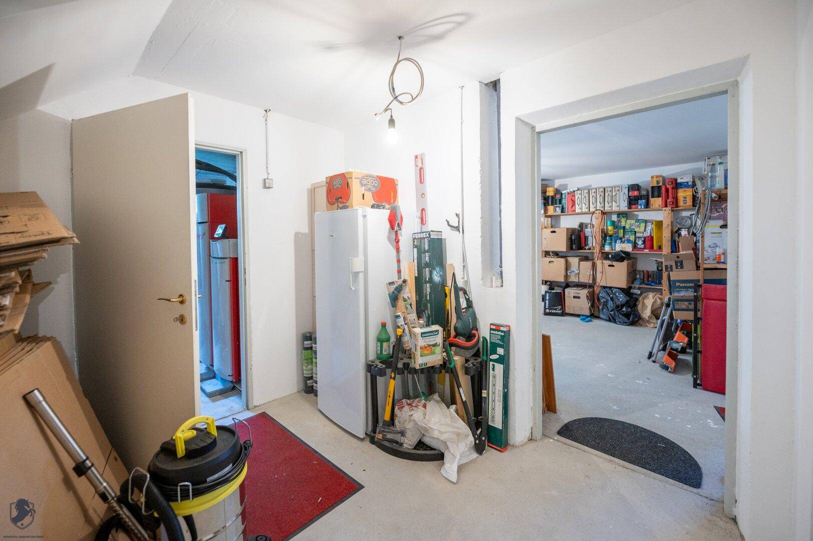 Kellerraum mit Kühlschrank und verschiedenen Werkzeugen, ideal als Werkstatt oder Lagerfläche.