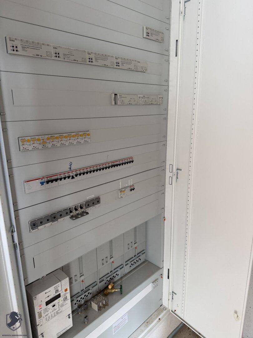 Offener Schaltschrank mit zahlreichen Sicherungen und Verkabelungen, typisch für einen Technikraum.