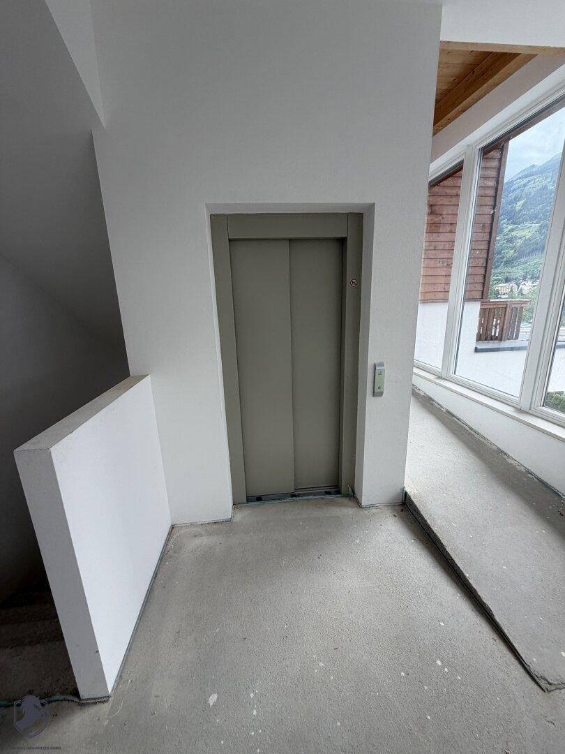 Aufzug und Rampe in einem unfertigen Innenbereich, der Barrierefreiheit und Komfort bietet.