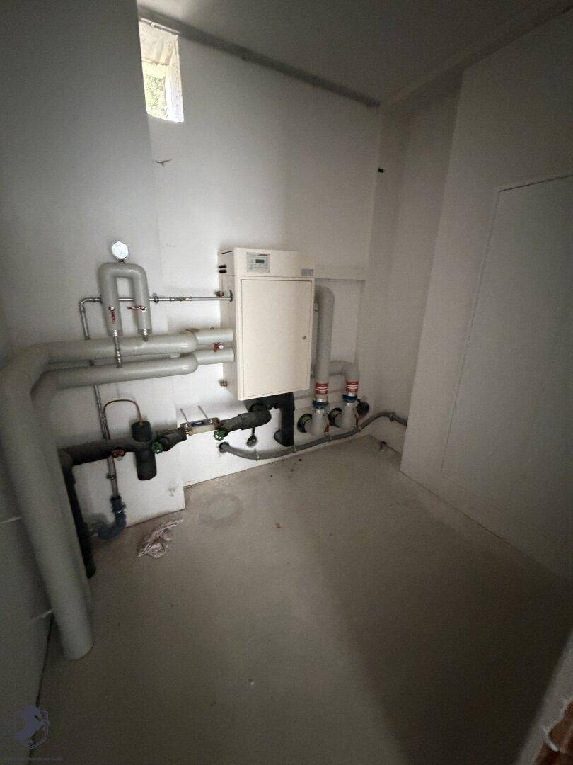 Technikraum mit Heizungsanlage und Rohren, bereit für die Inbetriebnahme, effiziente Haustechnik.