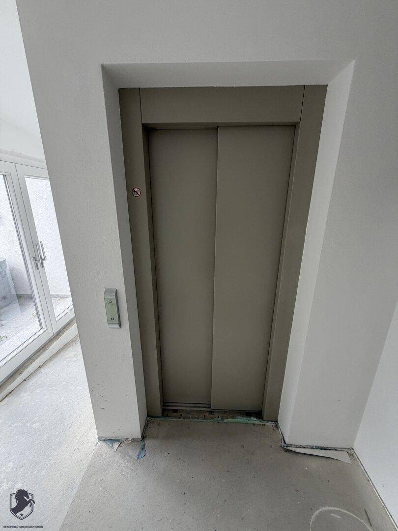 Aufzugstür in einem Flur eines im Bau befindlichen Gebäudes, bereit für den Einbau.