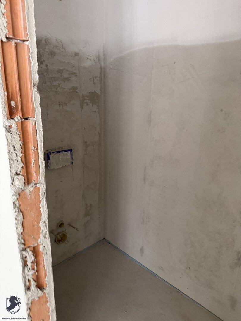 Kleiner Raum im Rohbau mit unverputzten Wänden und sichtbarem Mauerwerk, ideal als Abstellraum.