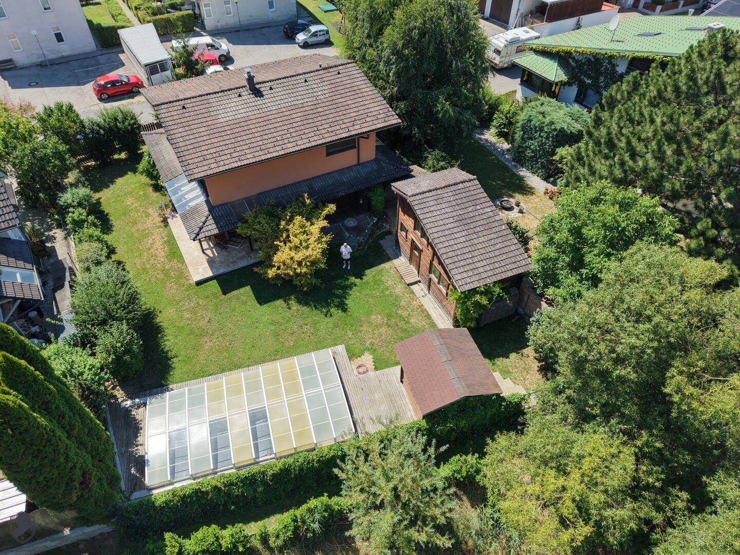 Luftaufnahme des Anwesens mit Haupthaus, Nebengebäude, überdachtem Pool und großem Gartenbereich.
