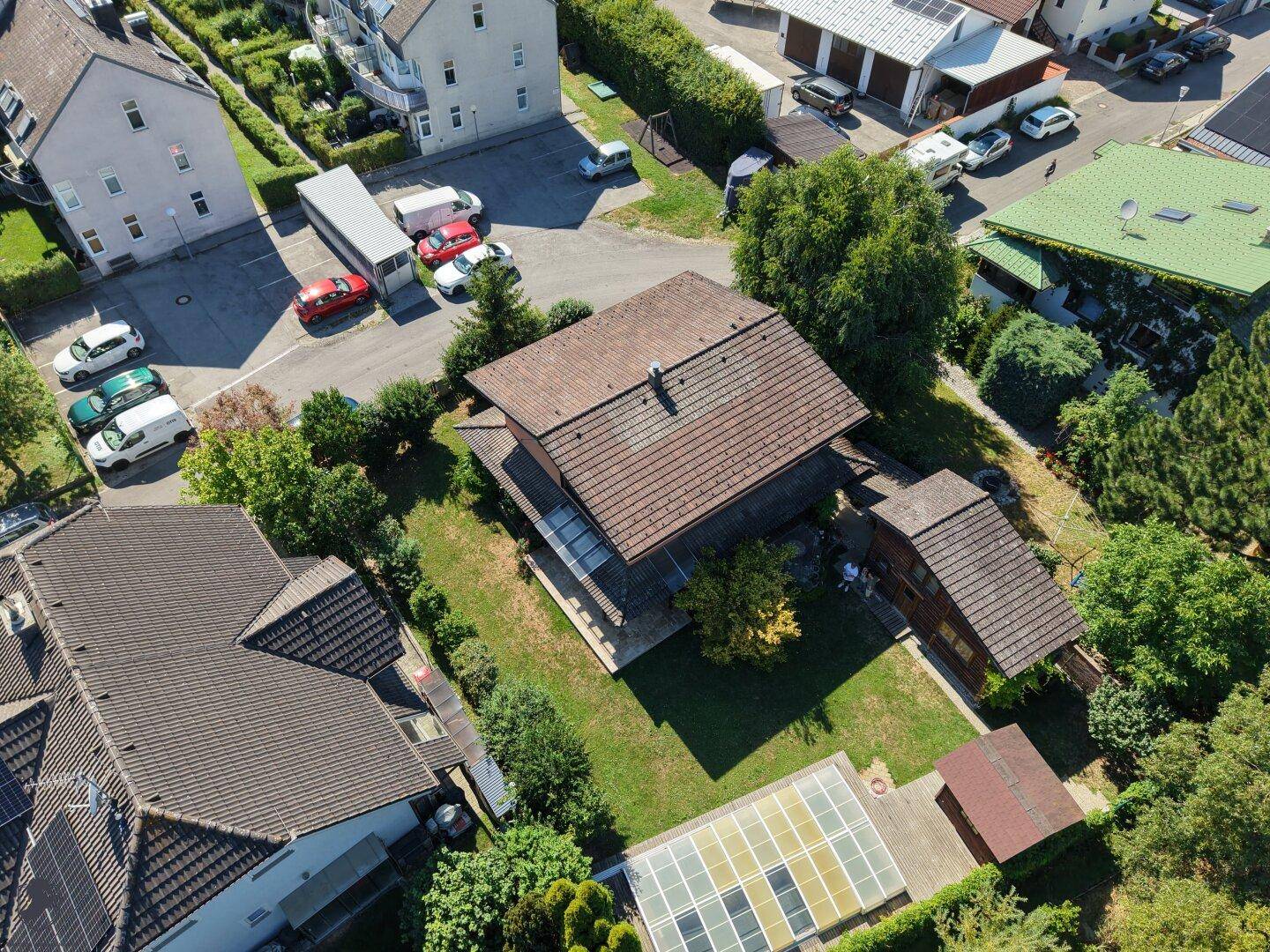 Weitläufige Luftaufnahme des Anwesens mit Haupthaus, Nebengebäude, Pool und umliegender Nachbarschaft.