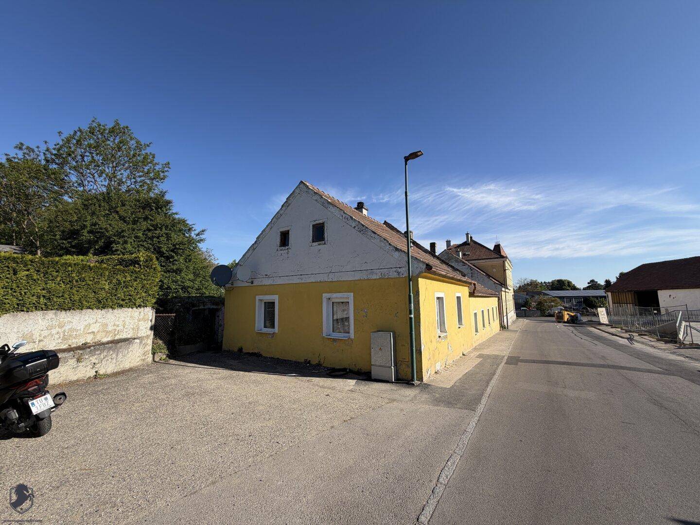 Gelbes Landhaus mit Satteldach und weitem Blick auf die ländliche Umgebung.