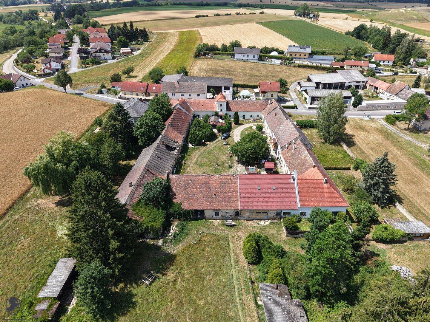 Weitläufiges ländliches Anwesen mit mehreren Gebäuden und großem Innenhof aus der Vogelperspektive.