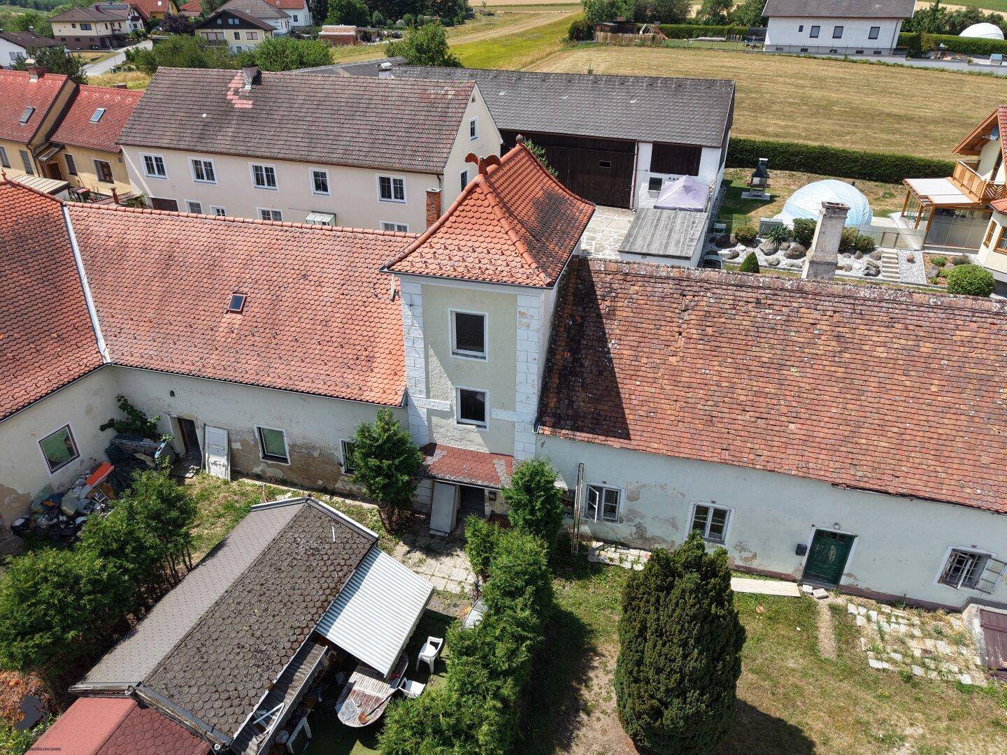Detailansicht eines historischen Gebäudeteils mit Turm und roten Ziegeldächern im ländlichen Anwesen.