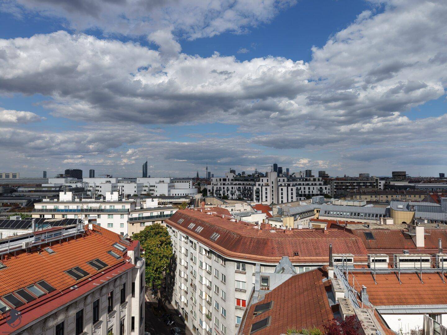 Weitläufiger Stadtblick mit einer Mischung aus modernen und traditionellen Gebäuden unter einem blauen Himmel.