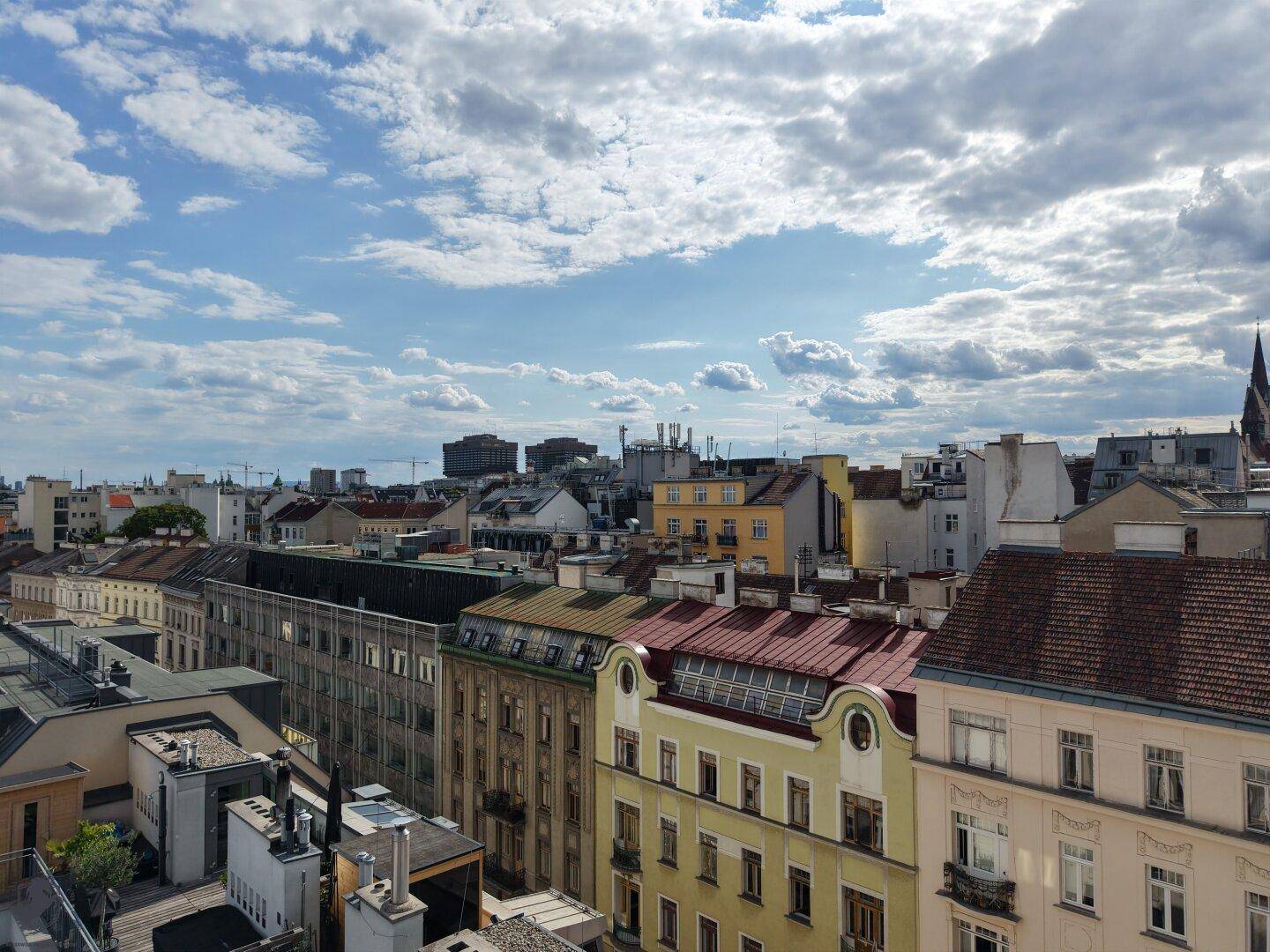 Umfassender Stadtblick mit unterschiedlichen Gebäudefassaden und Dächern, die die urbane Vielfalt zeigen.