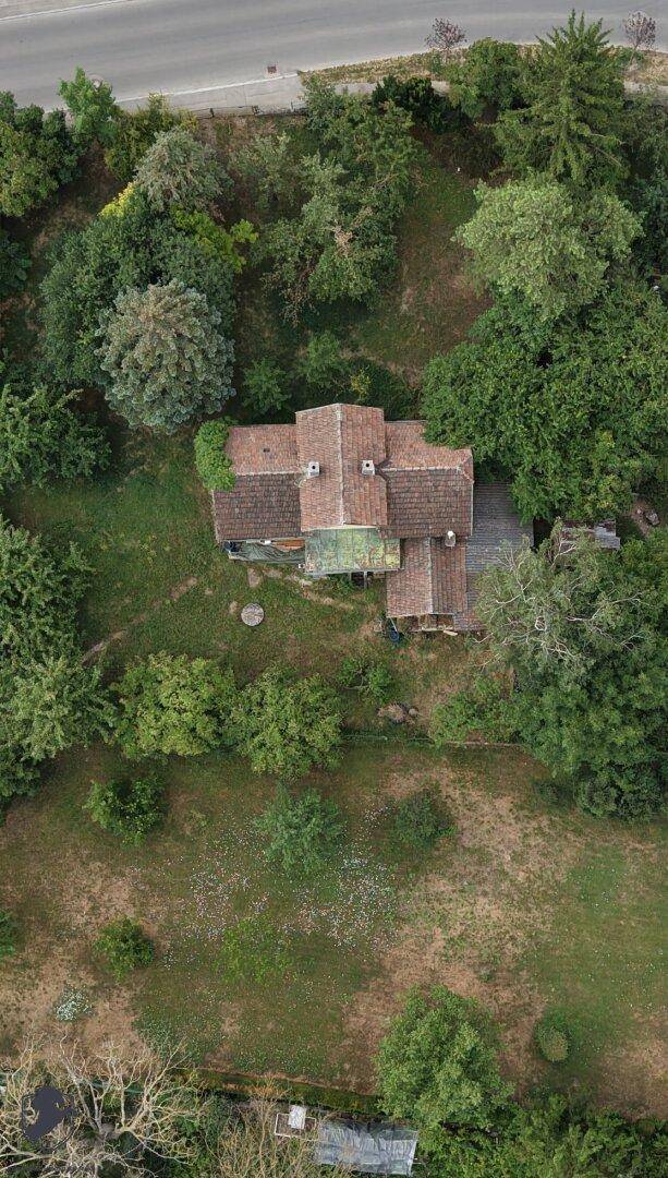 Senkrechte Luftaufnahme des Hauses mit weitläufigem, naturbelassenem Garten und altem Baumbestand.