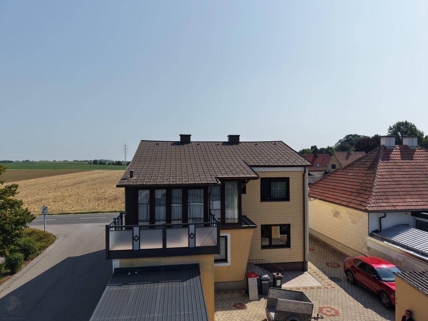 Vogelperspektive eines Hauses mit Balkon und Blick auf die umliegende Landschaft.