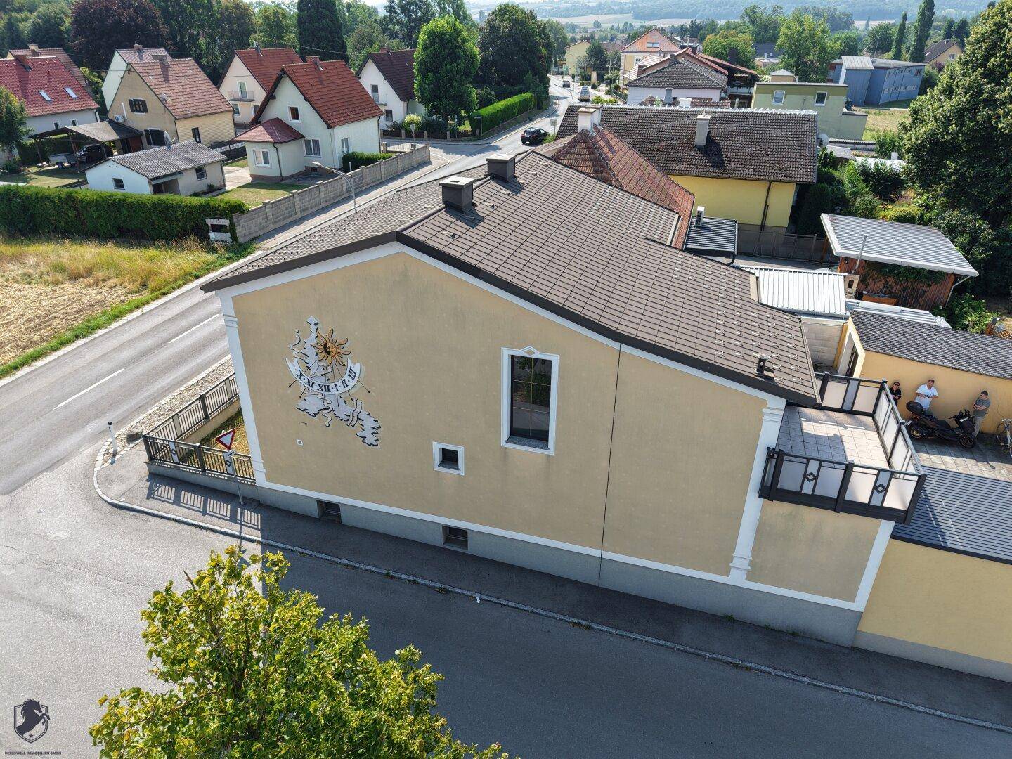 Seitenansicht des Hauses mit Sonnenuhr und Blick auf die Nachbarschaft.