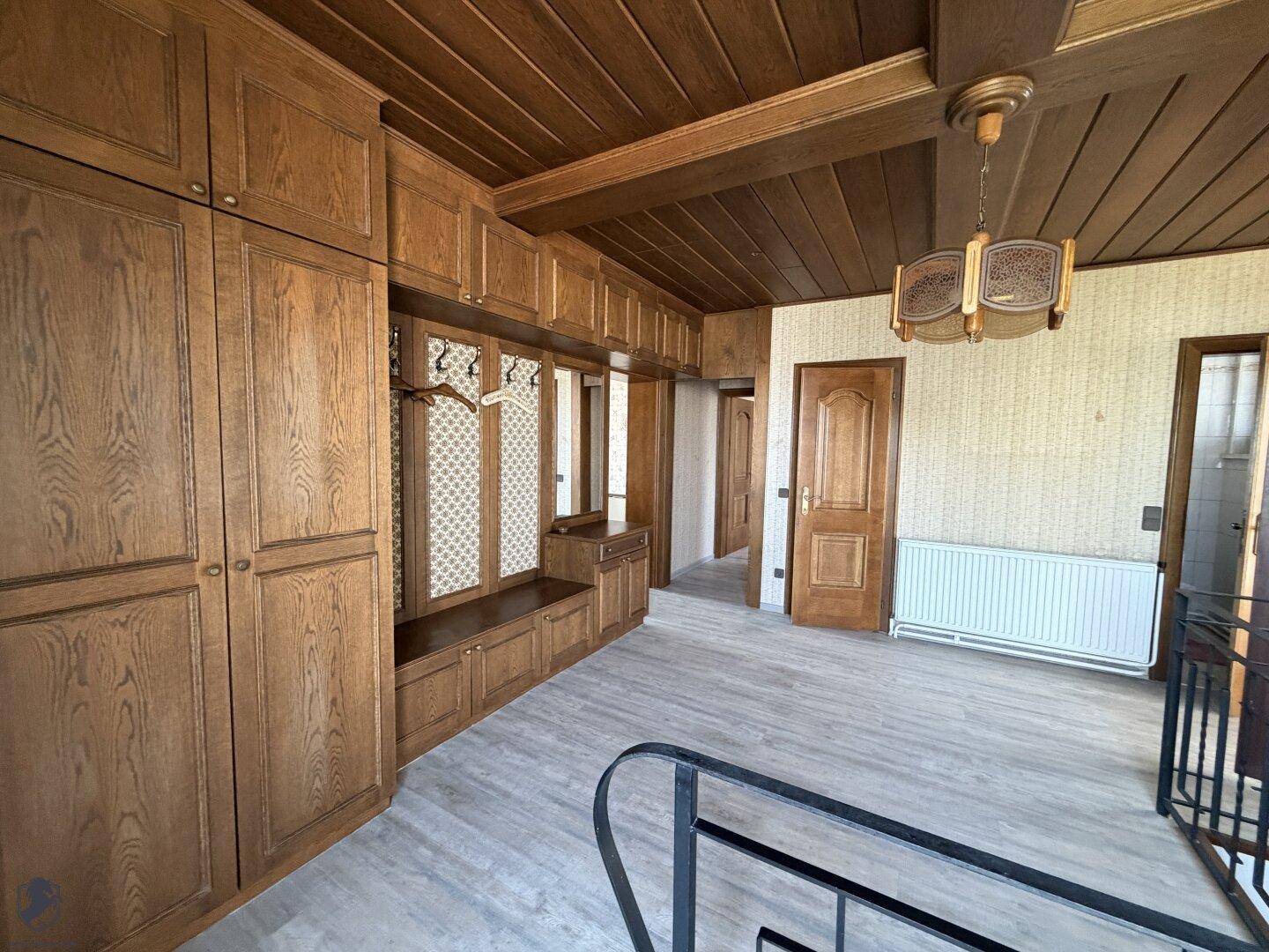 Flur im Obergeschoss mit Einbauschränken aus Holz und Holzdeckenverkleidung.