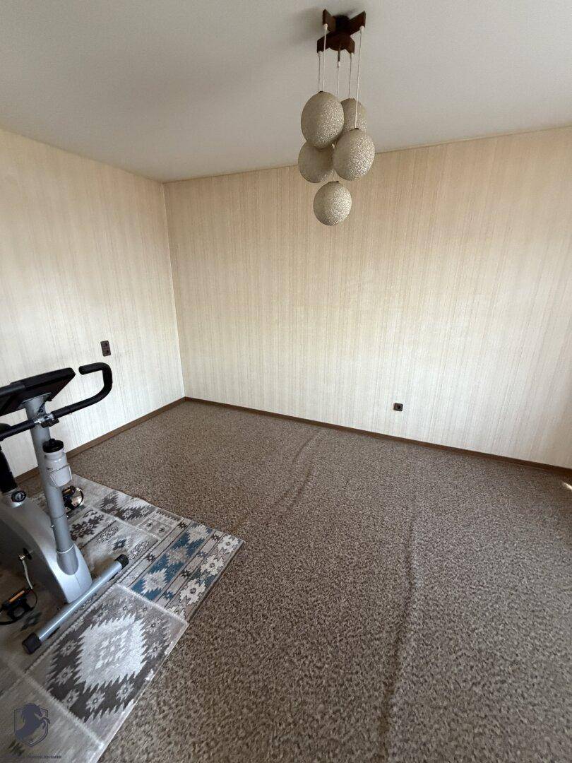 Schlafzimmer oder Fitnessraum mit Teppichboden und einem Heimtrainer.