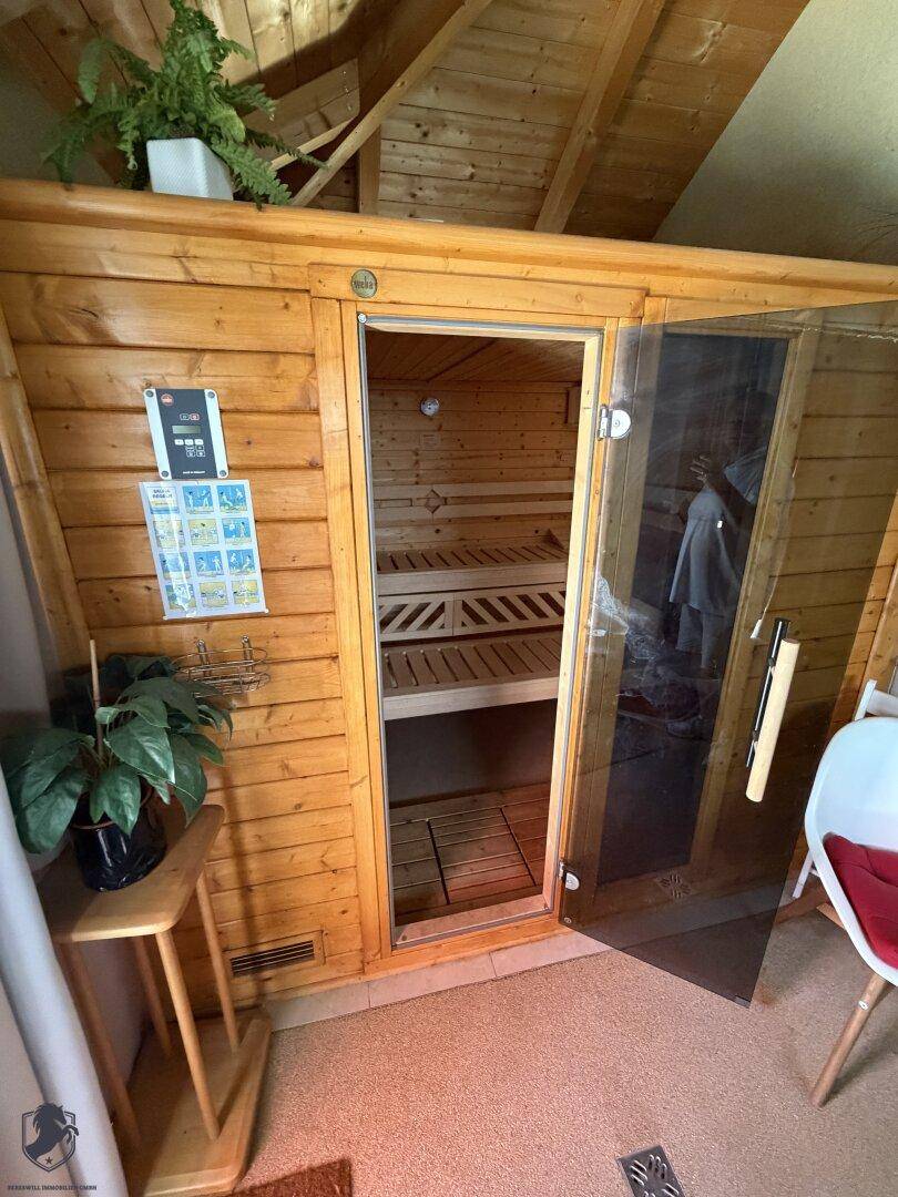 Gemütliche Holzsauna mit Glastür und Holzbalken an der Decke, ideal zur Entspannung im Haus.