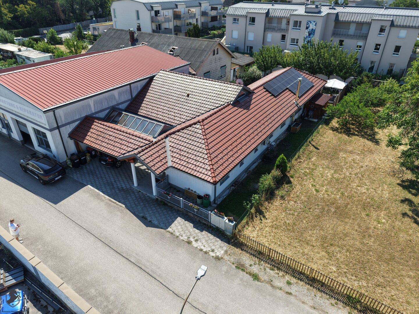 Luftaufnahme des Anwesens mit Haus, angrenzendem Grundstück und umliegenden Gebäuden.