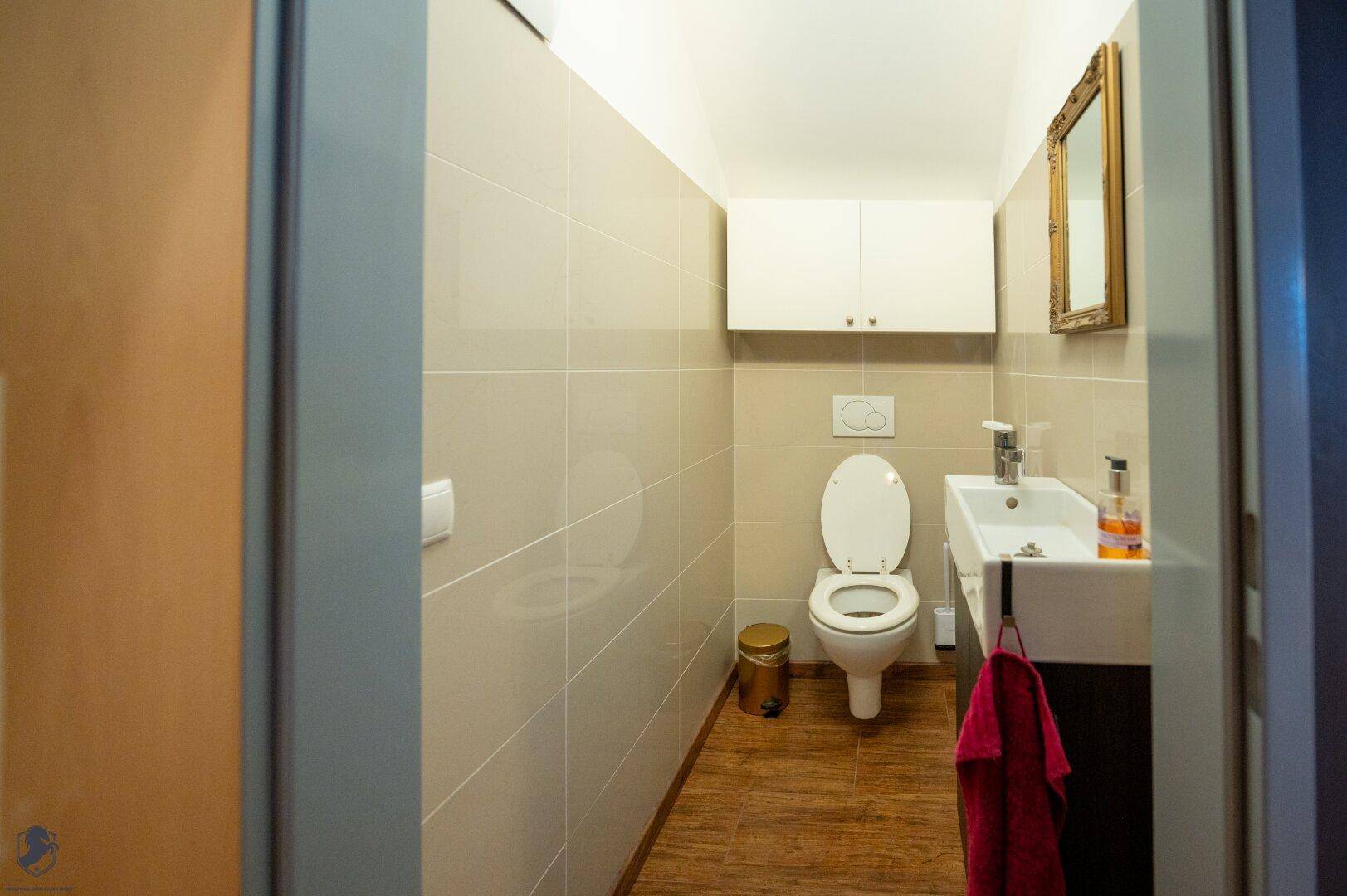 Helles Gäste-WC mit wandhängender Toilette, modernem Waschbecken und Fliesenboden.