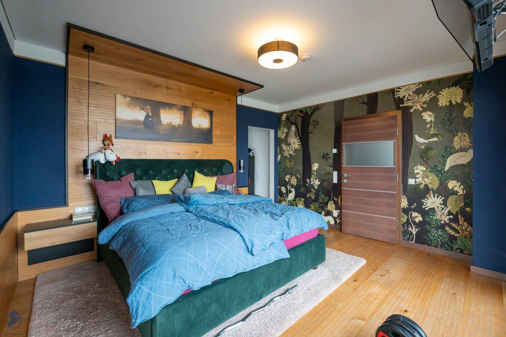 Gemütliches Schlafzimmer mit großem Bett, Holzakzenten und auffälliger Tapete.