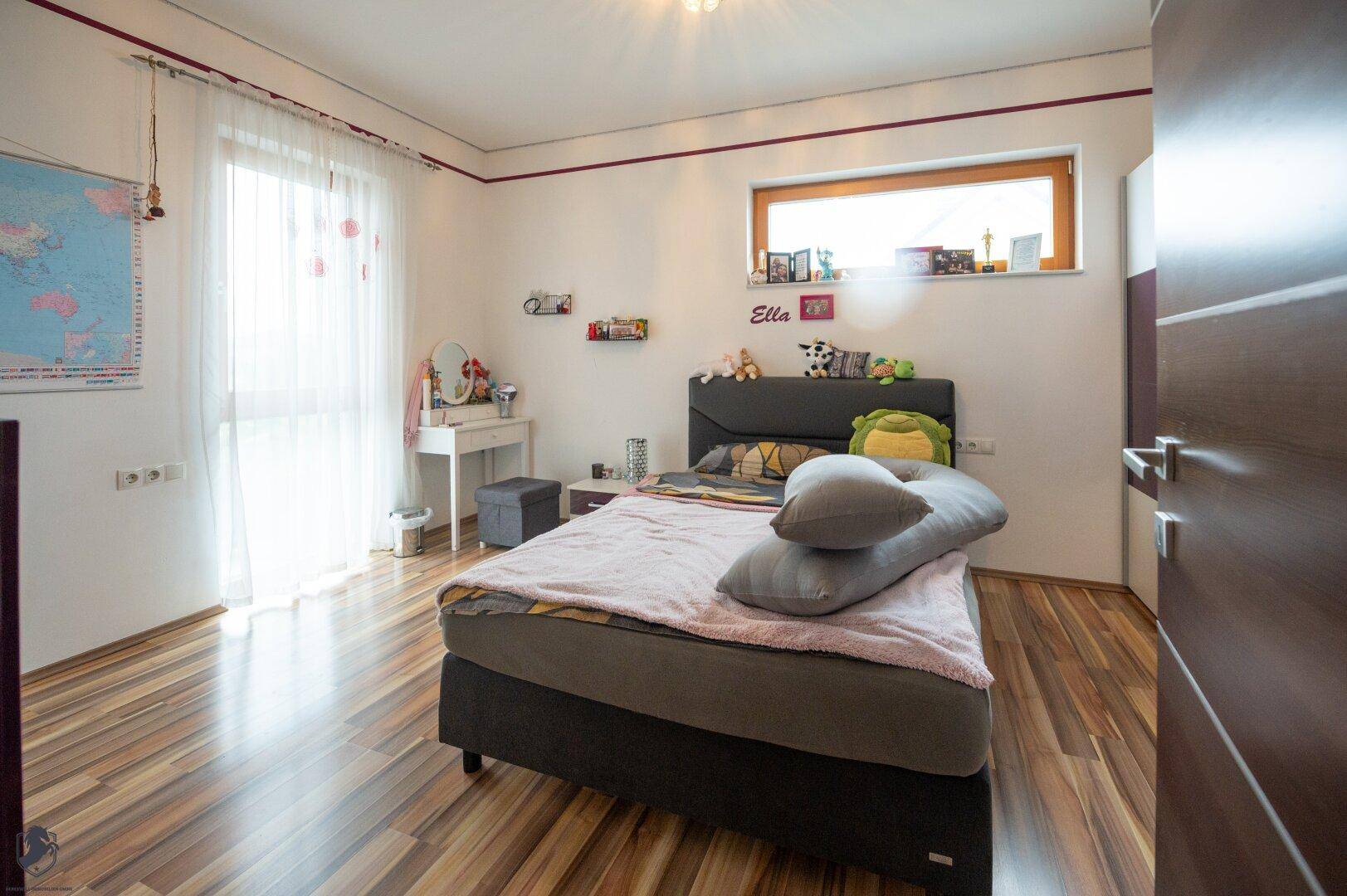 Helles Kinderzimmer mit Einzelbett, Schreibtisch und großem Fenster für viel Tageslicht.