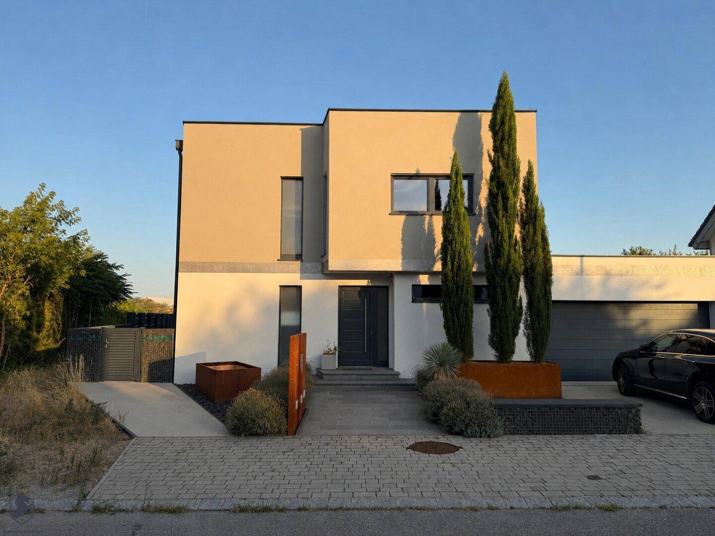 Moderne Hausfassade mit klaren Linien, gepflegtem Vorgarten und integrierter Garage.
