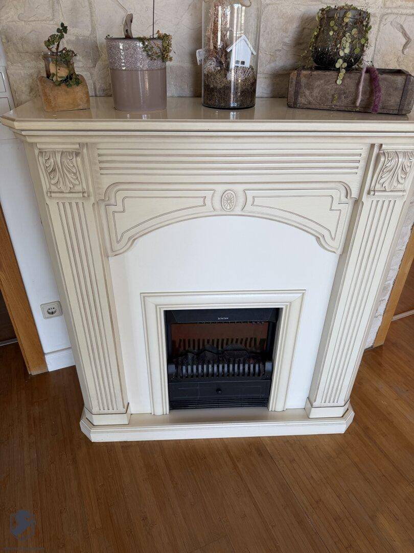 Dekorativer Kamin mit elektrischem Einsatz und klassischem Design im Wohnbereich.