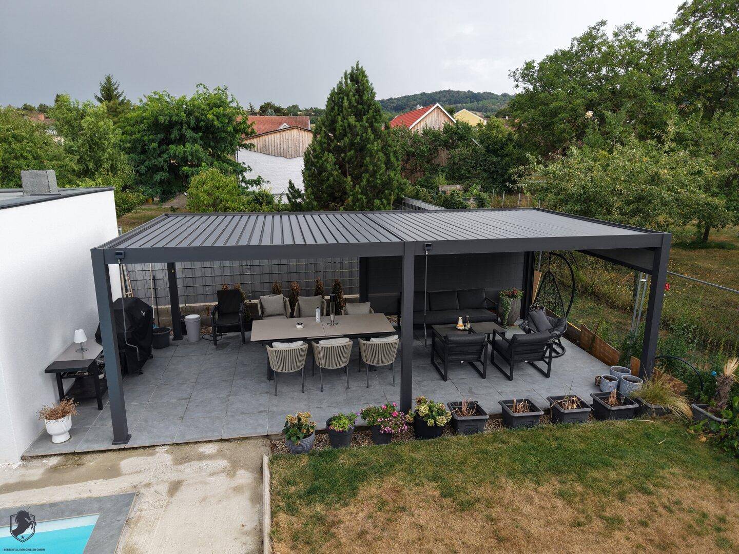 Großzügige überdachte Terrasse mit modernem Ess- und Loungebereich, ideal für entspannte Stunden im Freien.