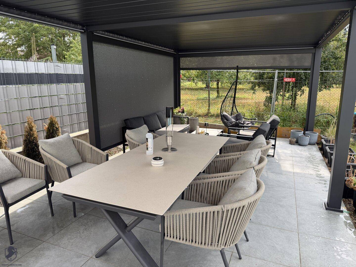 Detailansicht der überdachten Terrasse mit hochwertigen Outdoor-Möbeln für Essen und Entspannung.