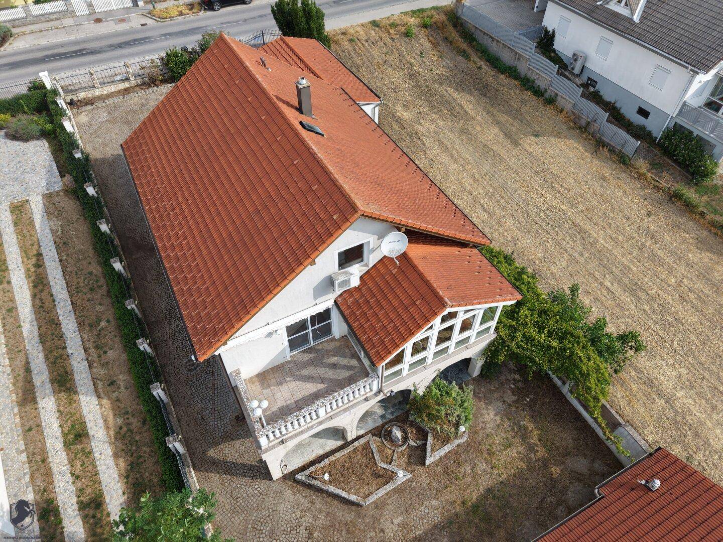 Vogelperspektive des Hauses mit Terrasse, Wintergarten und weitläufigem Gartenbereich.