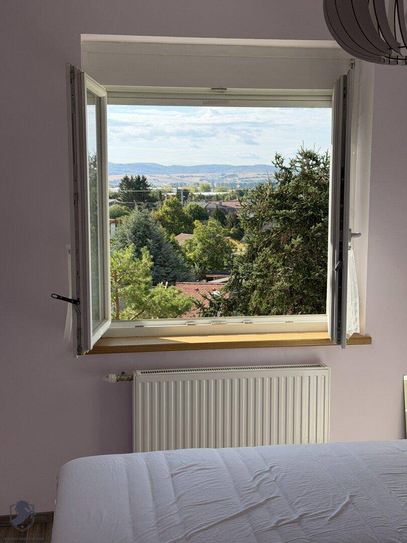 Weitblick aus dem Schlafzimmerfenster über grüne Hügel und die umliegende Landschaft.