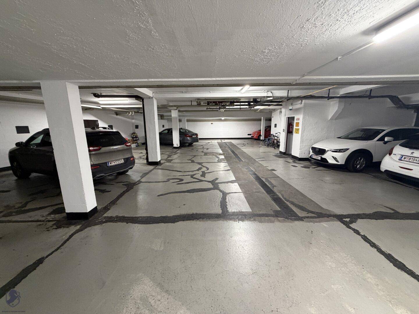 Tiefgarage mit mehreren Stellplätzen und Betonboden, bietet sichere Parkmöglichkeiten.