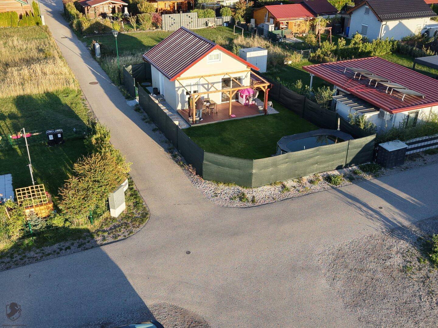 Luftaufnahme eines Einfamilienhauses mit Garten, Terrasse und kleinem Pool in ländlicher Umgebung.