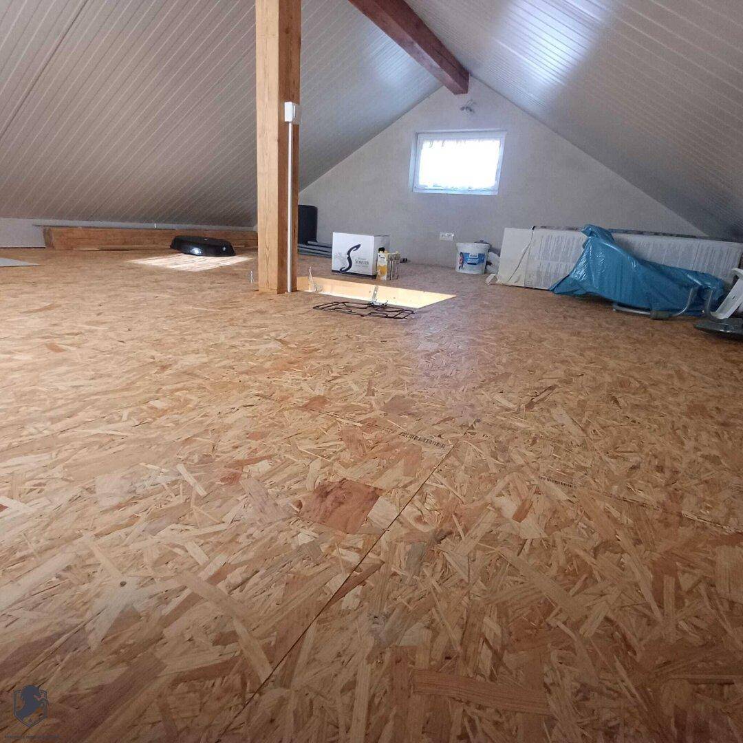Geräumiger Dachboden mit Holzfußboden und schrägen Wänden, bereit für den Ausbau.