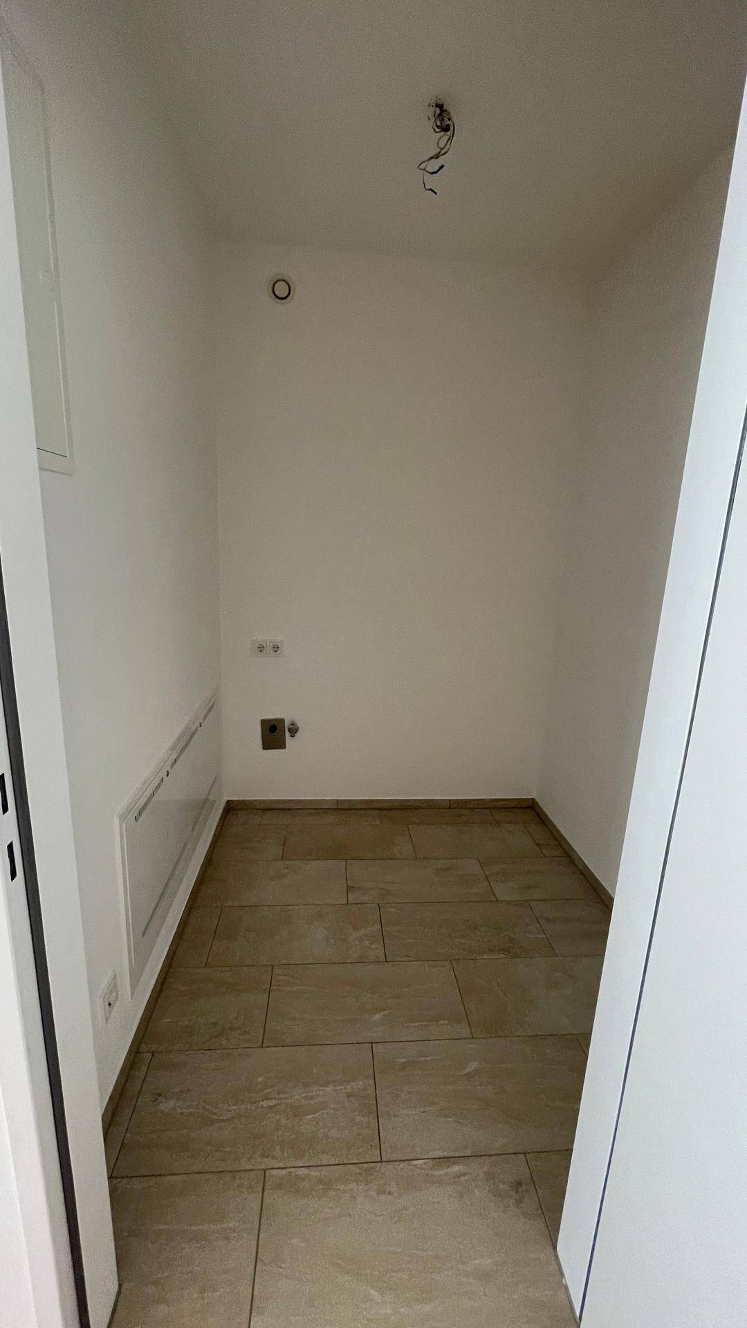 Praktischer Abstellraum mit Fliesenboden, ideal für Lagerung oder Haushaltsgeräte.