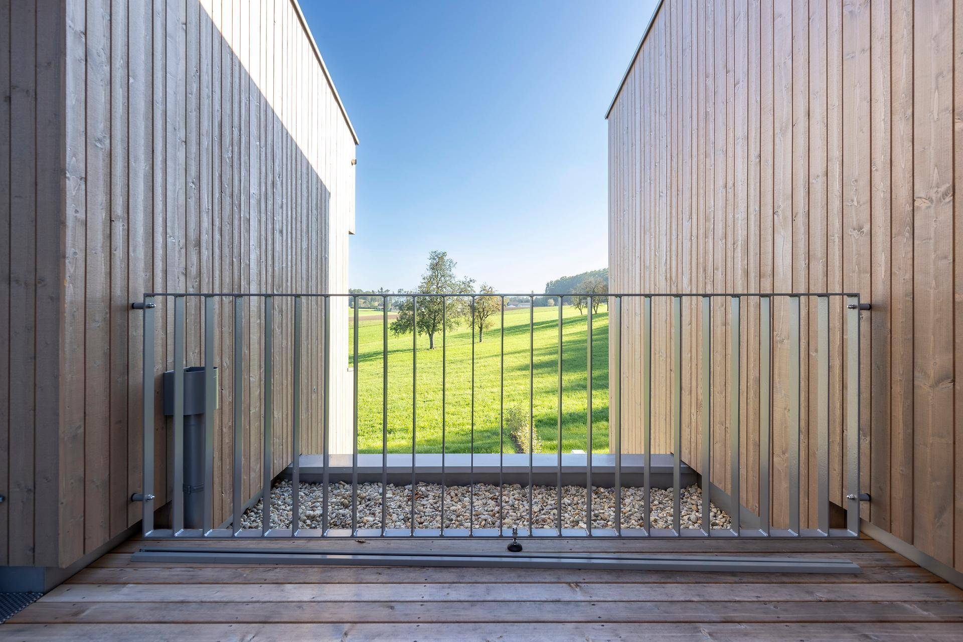 Kleiner Balkon mit Metallgeländer und Blick auf die umliegende Landschaft.