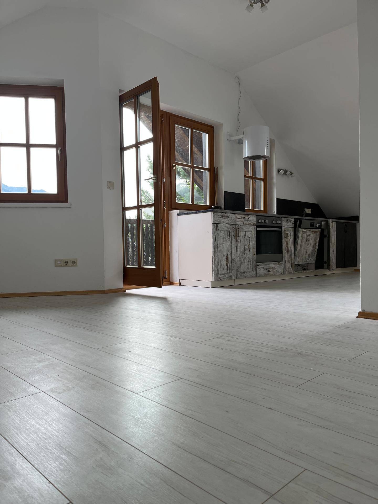 Offene Küche mit Einbaugeräten und direktem Zugang zum Balkon, hell und funktional.