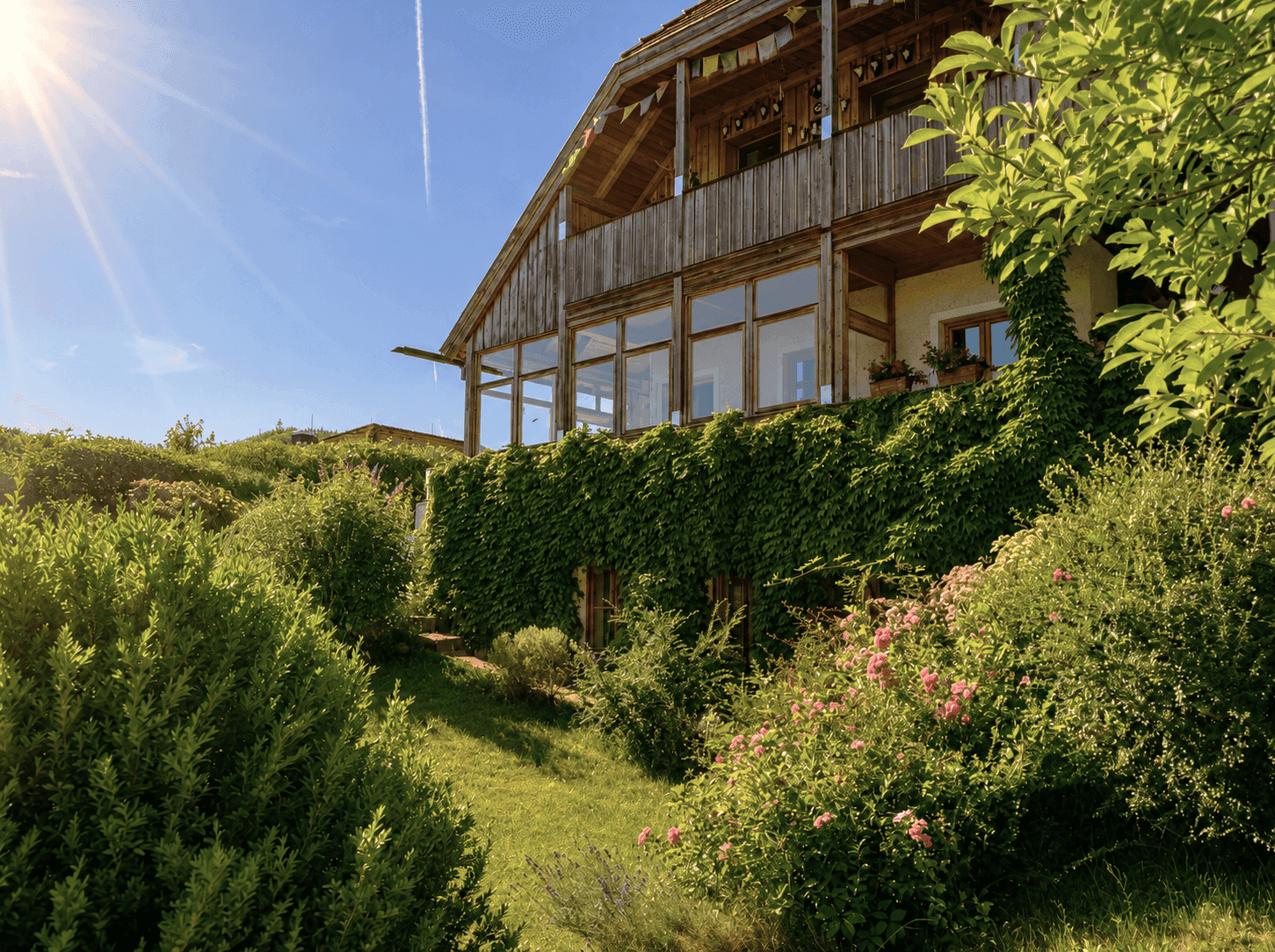 Charmantes Haus mit bewachsener Fassade, Holzbalkon und üppigem Garten in sonniger Lage.