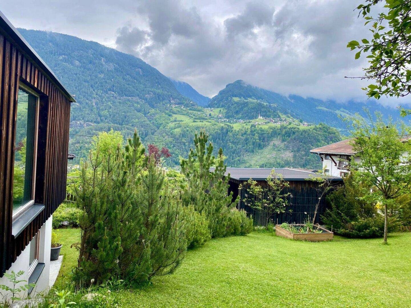 Gepflegter Garten mit Hochbeet und Blick auf die malerische Berglandschaft.