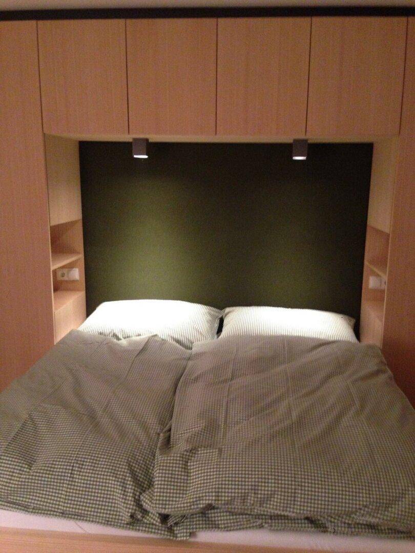 Gemütliches Schlafzimmer mit Doppelbett und integrierten Schränken aus hellem Holz.
