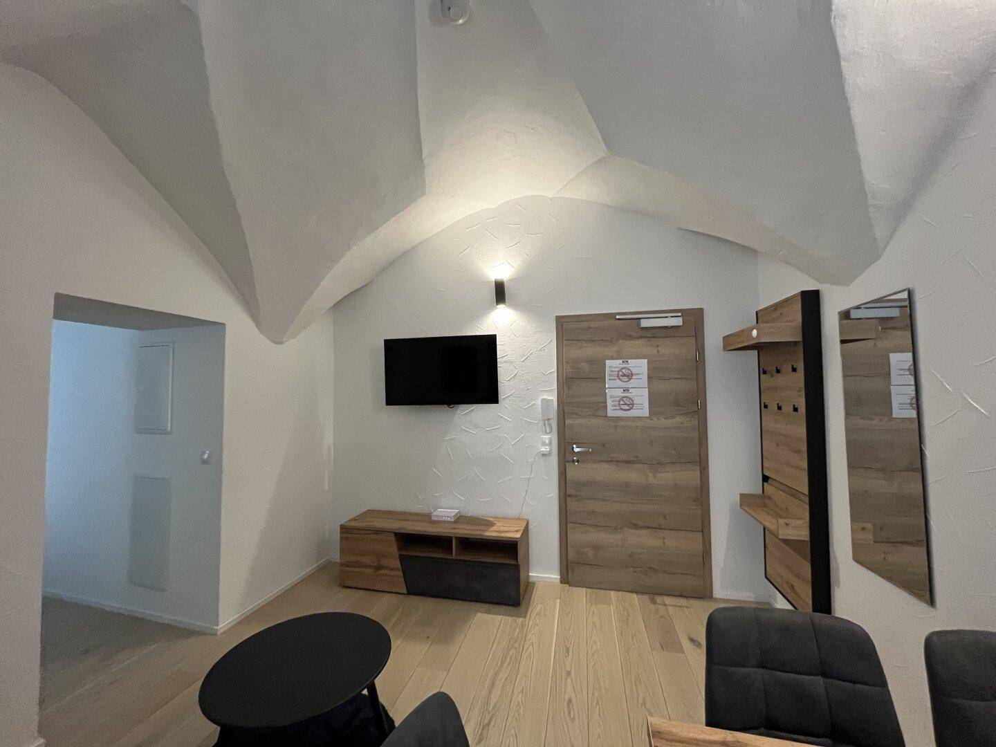 Eingangsbereich mit Fernseher, Garderobe und beeindruckender Gewölbedecke.