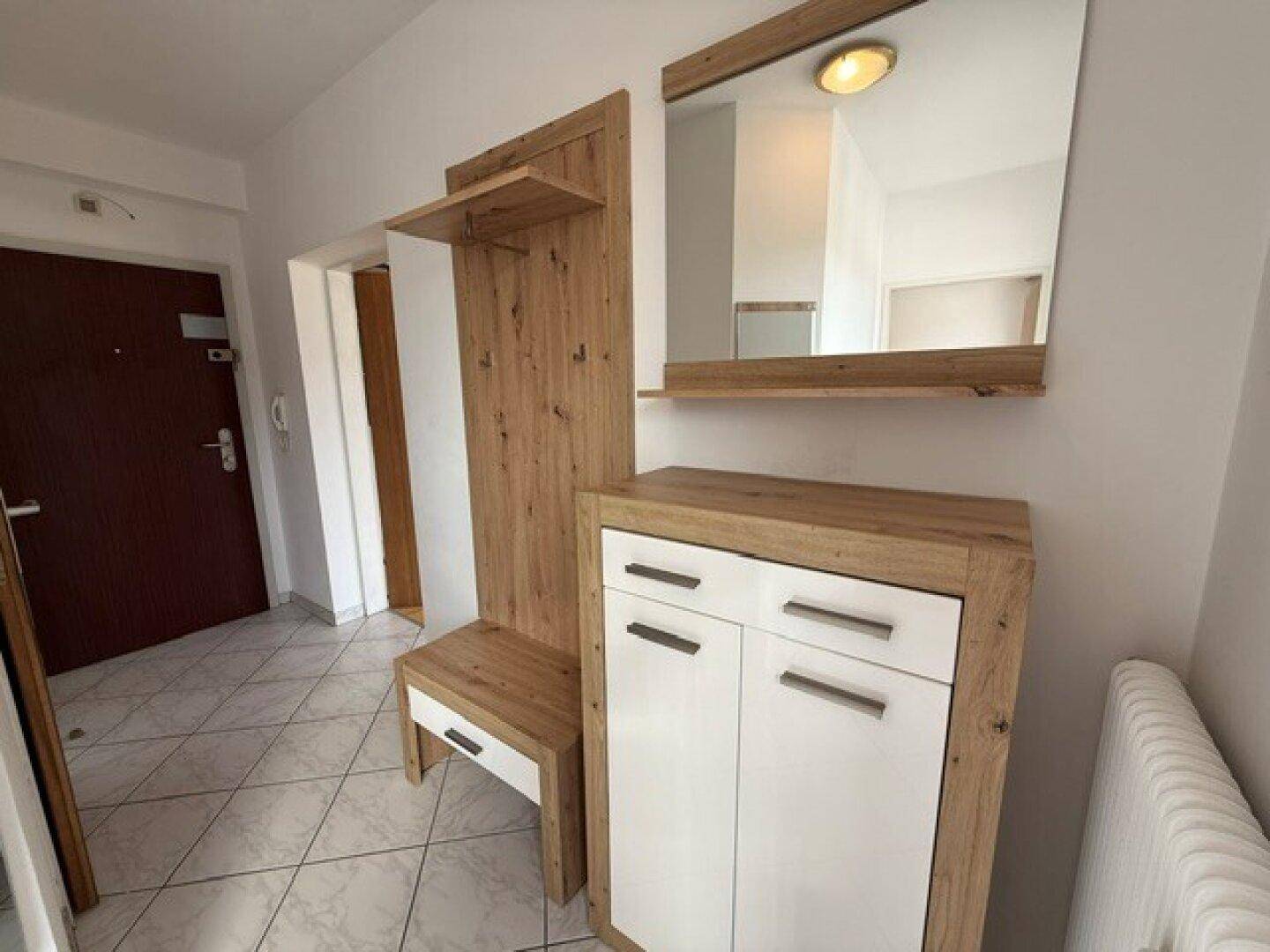 Eingangsbereich mit Fliesenboden, Garderobe und Spiegel, bietet einen praktischen Empfangsbereich.