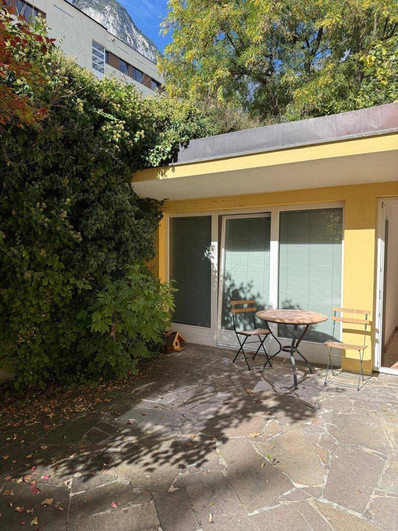 Kleine, gemütliche Terrasse mit Sitzgelegenheiten und üppiger Begrünung.