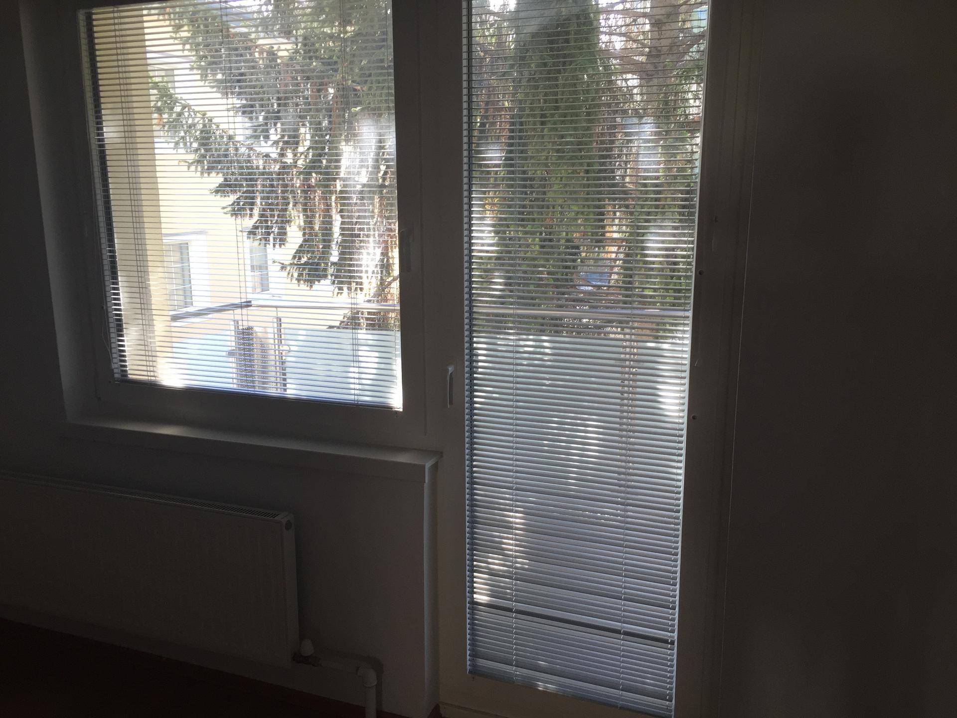 Raum mit Fenster und Balkonzugang, der viel Tageslicht hereinlässt und eine angenehme Atmosphäre schafft.