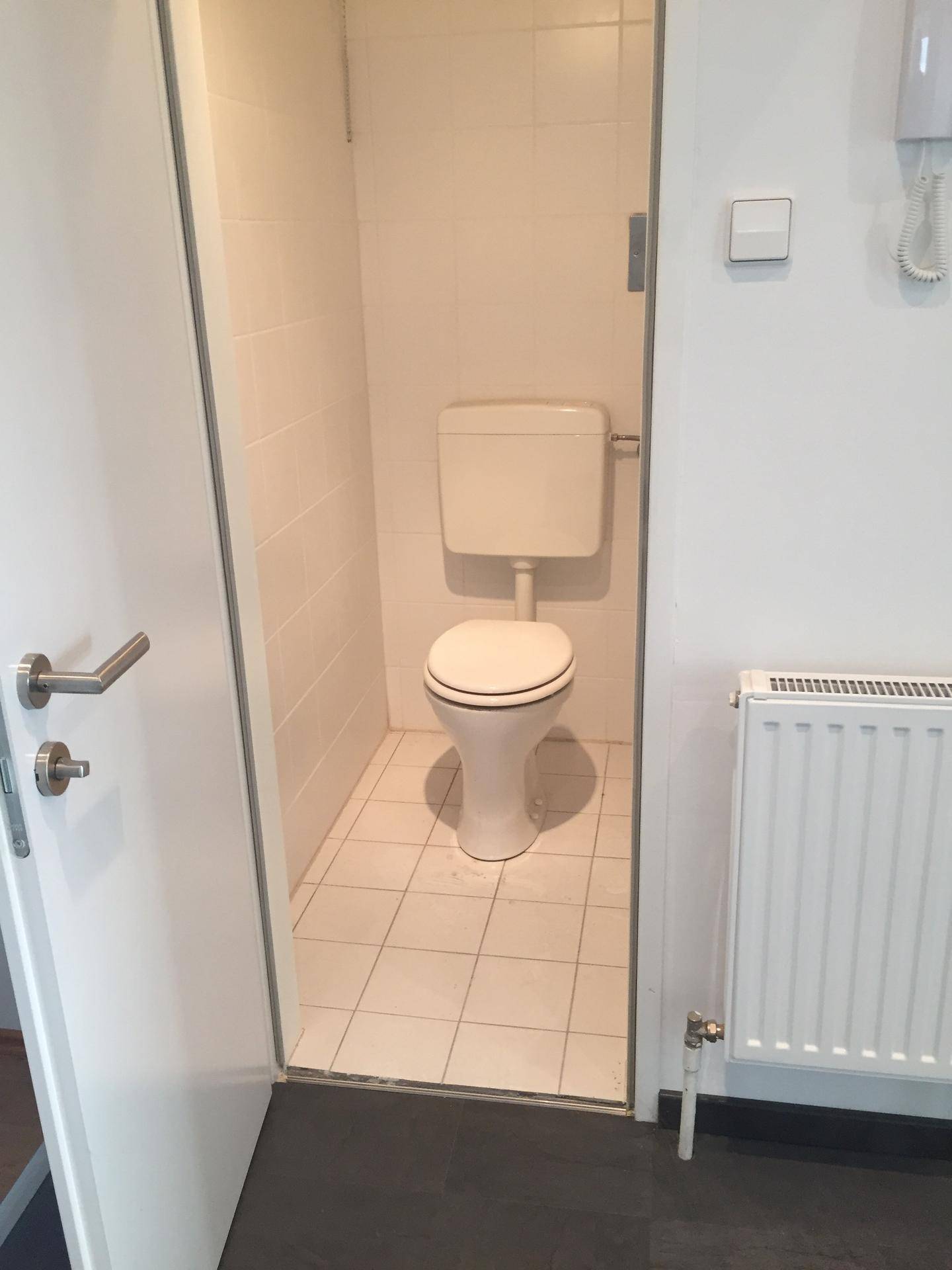 Separates WC mit Toilette und Fliesenboden, praktisch und gut zugänglich im Flurbereich.