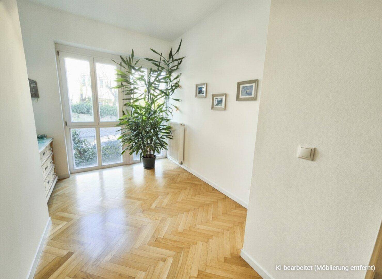 Heller Raum mit Fischgrätparkett und großem Fenster, das viel Tageslicht hereinlässt.