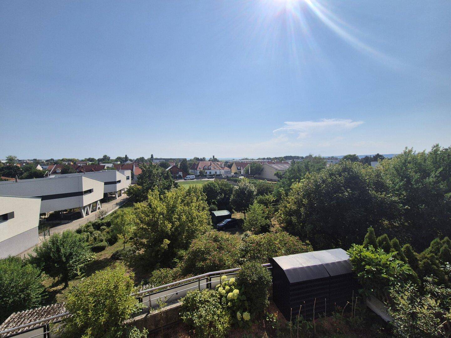 Weitläufige Aussicht über die grüne Umgebung und die Dächer der Stadt.
