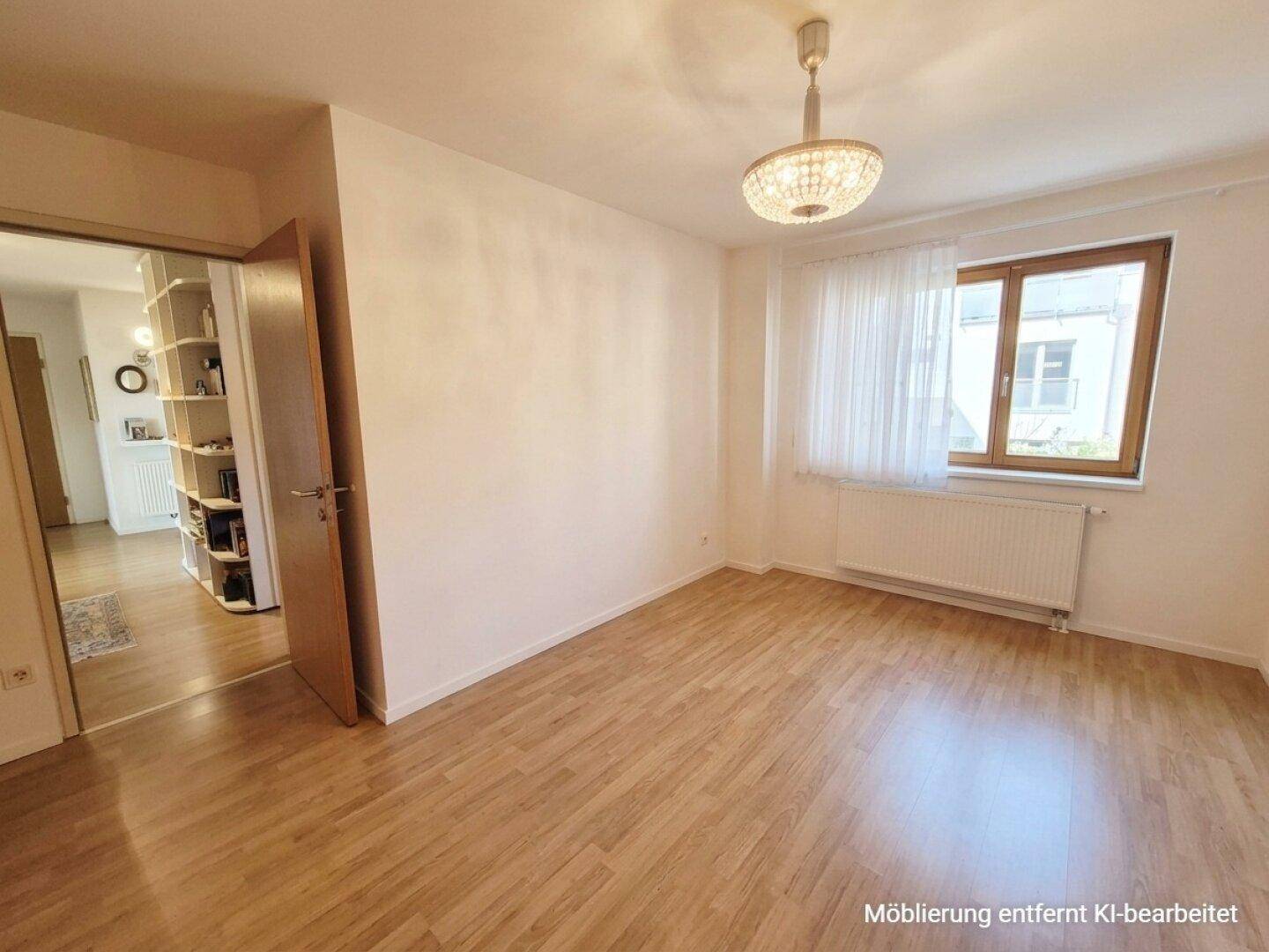 Helles Zimmer mit Laminatboden und Fenster, ideal als Schlafzimmer oder Arbeitsbereich.