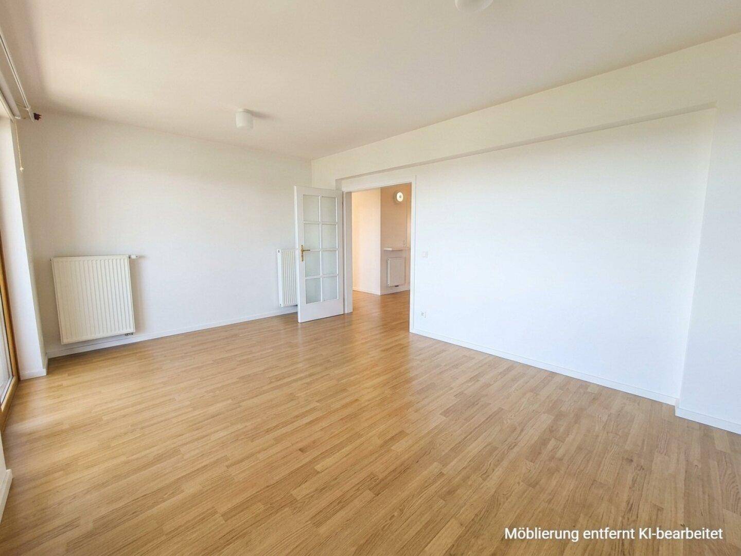 Leeres, helles Zimmer mit Laminatboden und Heizkörper, bereit für neue Einrichtungsideen.
