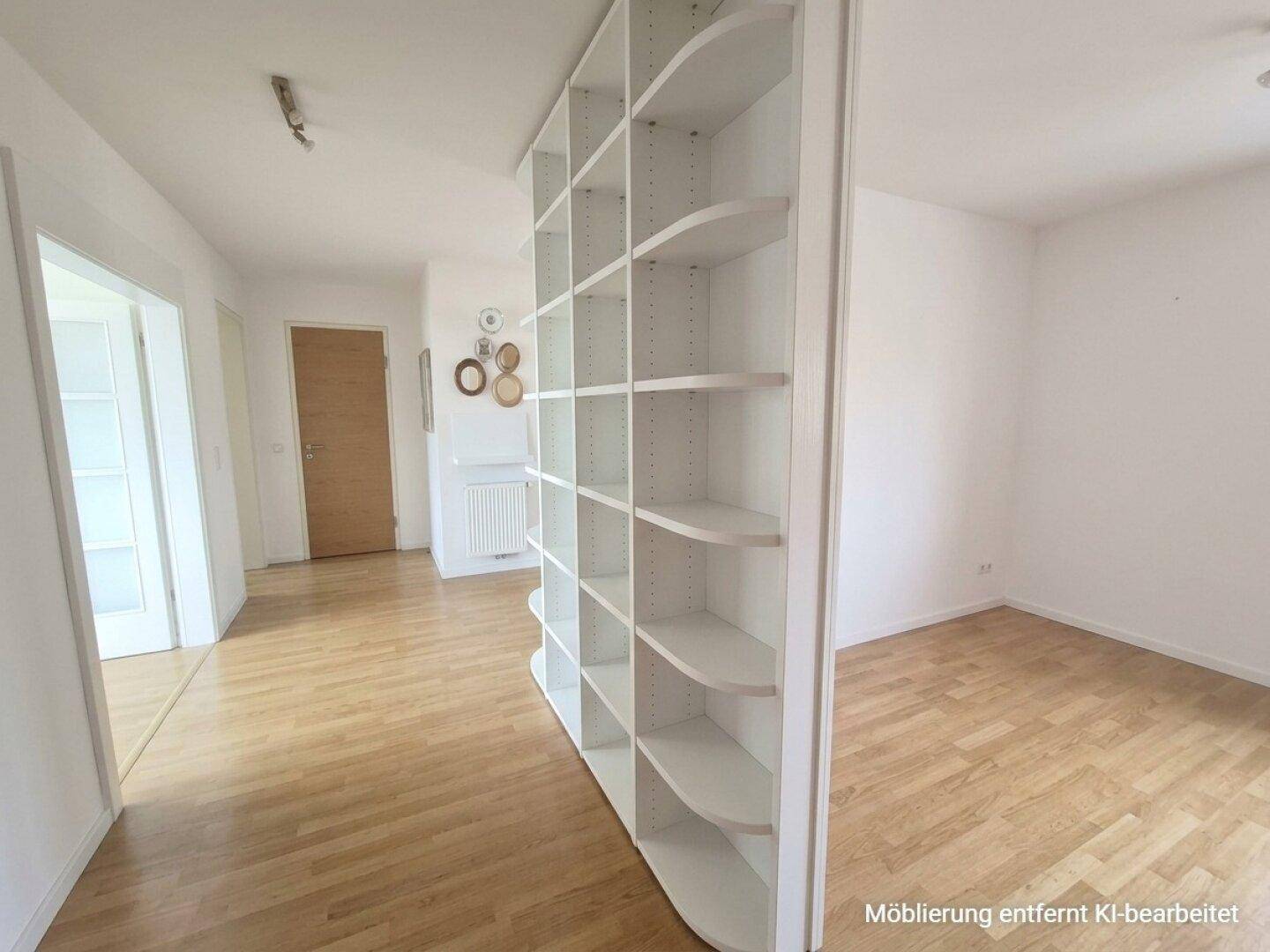 Heller Flur mit Laminatboden und einem offenen Regal als Raumteiler.